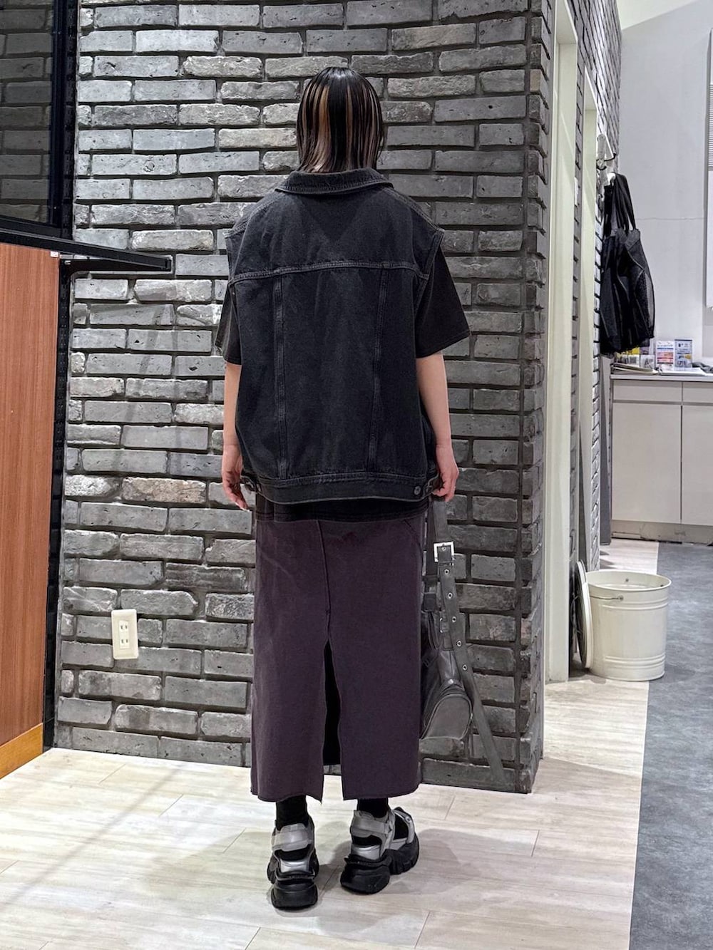 グレー系のサンダル、グレー系のショルダーバッグ、ブラック系のデニムジャケットを着用したレディースの春コーディネートの4枚目の写真