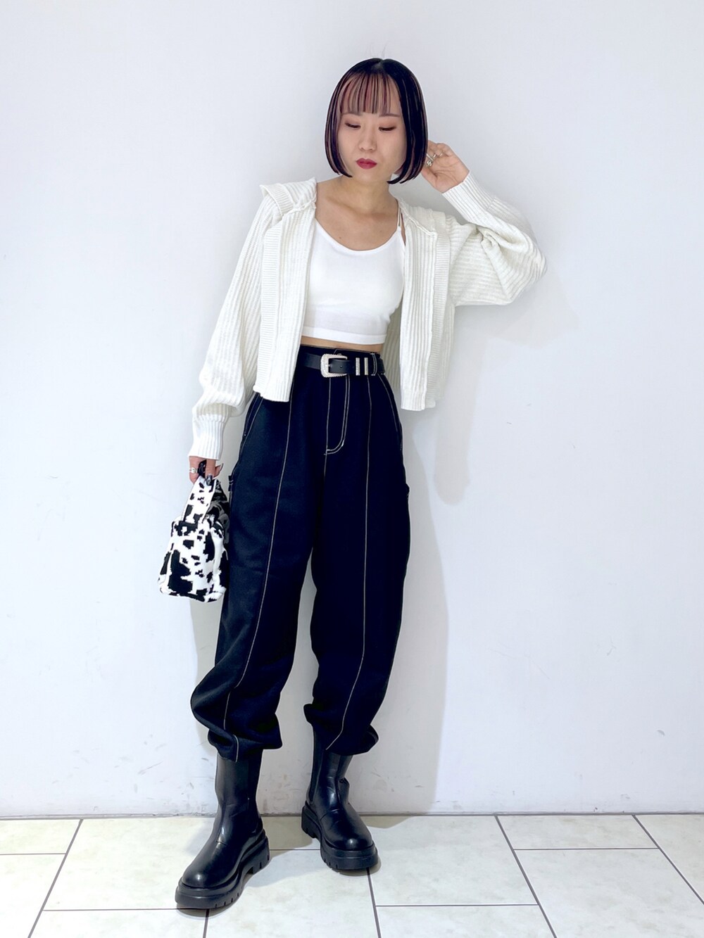 ホワイト系のキャミソール、ブラック系のハンドバッグ、ブラック系のその他パンツを着用したレディースの秋コーディネートの3枚目の写真