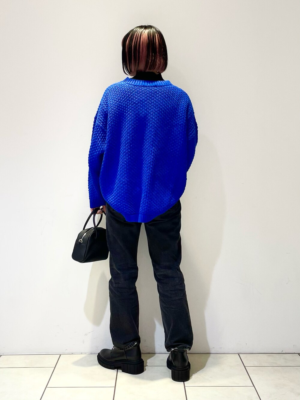 ブラック系のニット/セーター、ブルー系のニット/セーター、ブラック系のボストンバッグを着用したレディースの春コーディネートの3枚目の写真