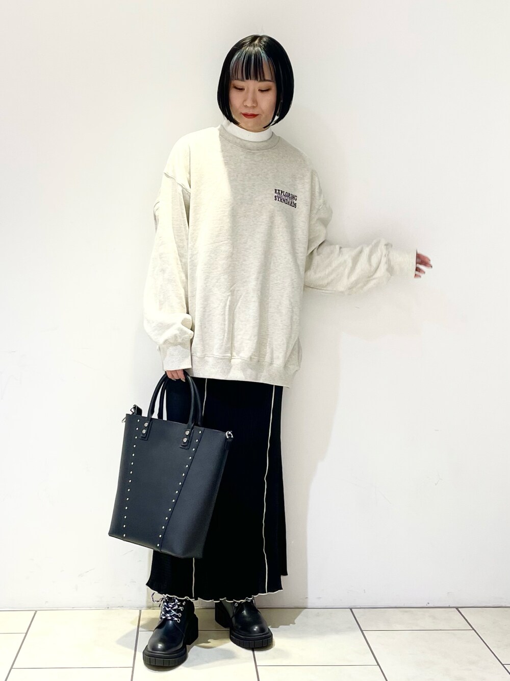 ホワイト系のニット/セーター、ベージュ系のスウェット、ブラック系のショルダーバッグを着用したレディースの春コーディネートの3枚目の写真