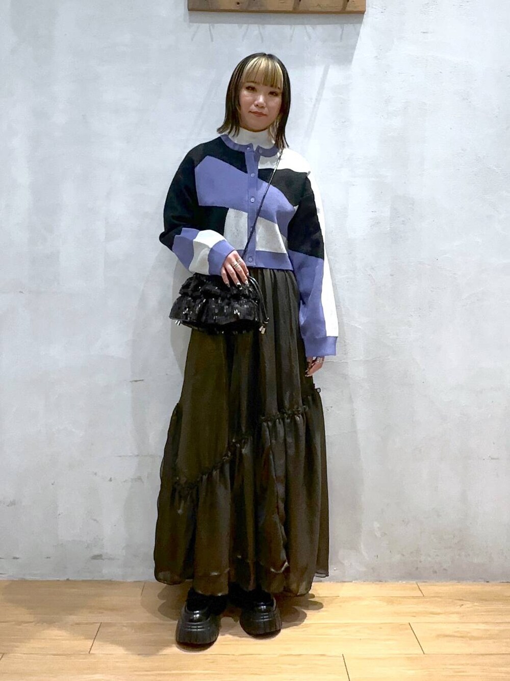 ブラック系のカーディガン/ボレロ、ブラック系のローファー、ブラック系のスカートを着用したレディースの春コーディネートの2枚目の写真