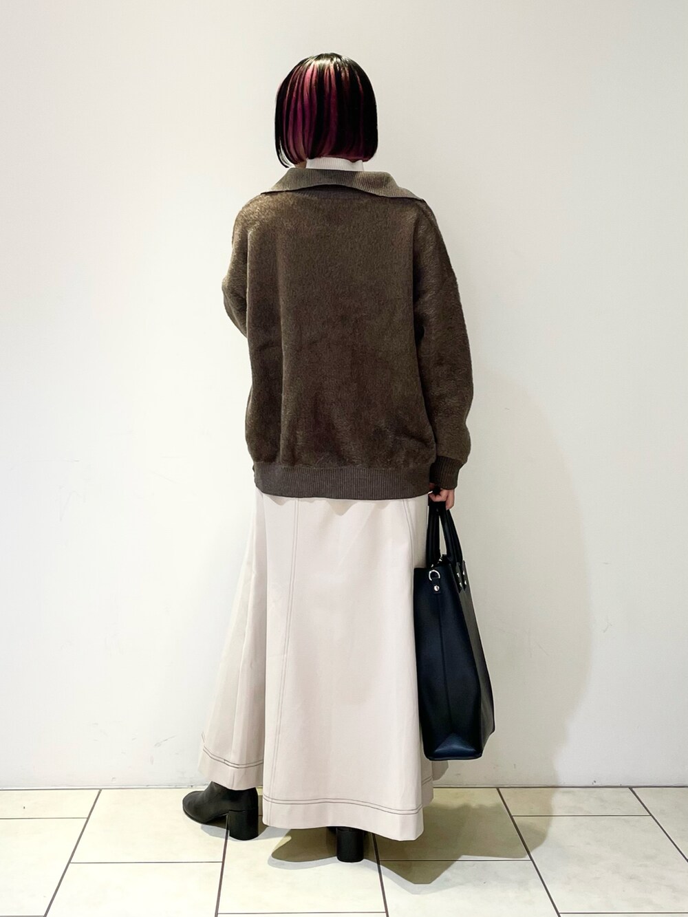 ホワイト系のニット/セーター、ブラウン系のニット/セーター、ブラック系のトートバッグを着用したレディースの冬コーディネートの3枚目の写真