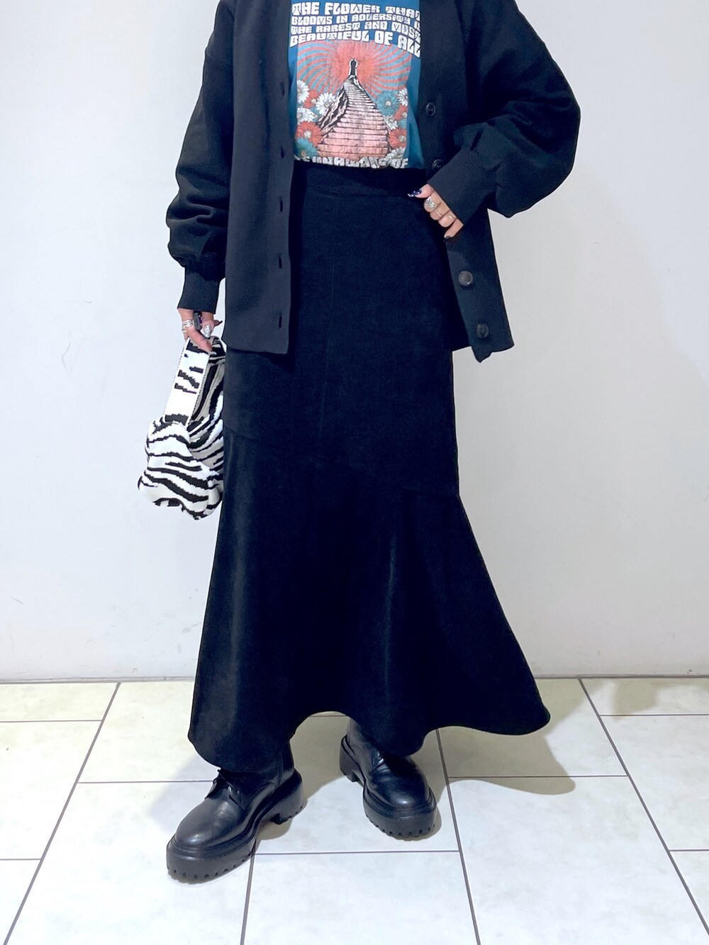 ブラック系のカーディガン/ボレロ、ブルー系のTシャツ/カットソー、ブラック系のスカートを着用したレディースの秋コーディネートの5枚目の写真