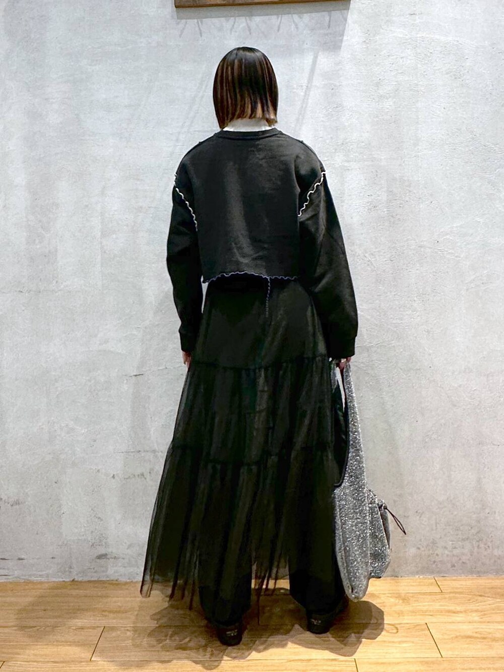 ホワイト系のTシャツ/カットソー、ブラック系のトートバッグ、ブラック系のスカートを着用したレディースの冬コーディネートの2枚目の写真