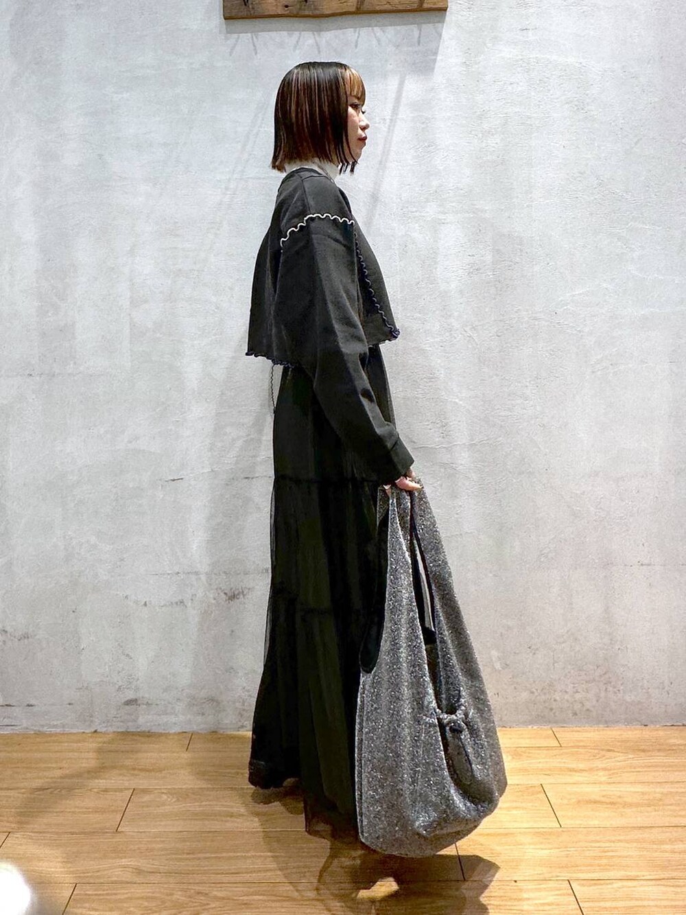 ホワイト系のTシャツ/カットソー、ブラック系のトートバッグ、ブラック系のスカートを着用したレディースの冬コーディネートの3枚目の写真