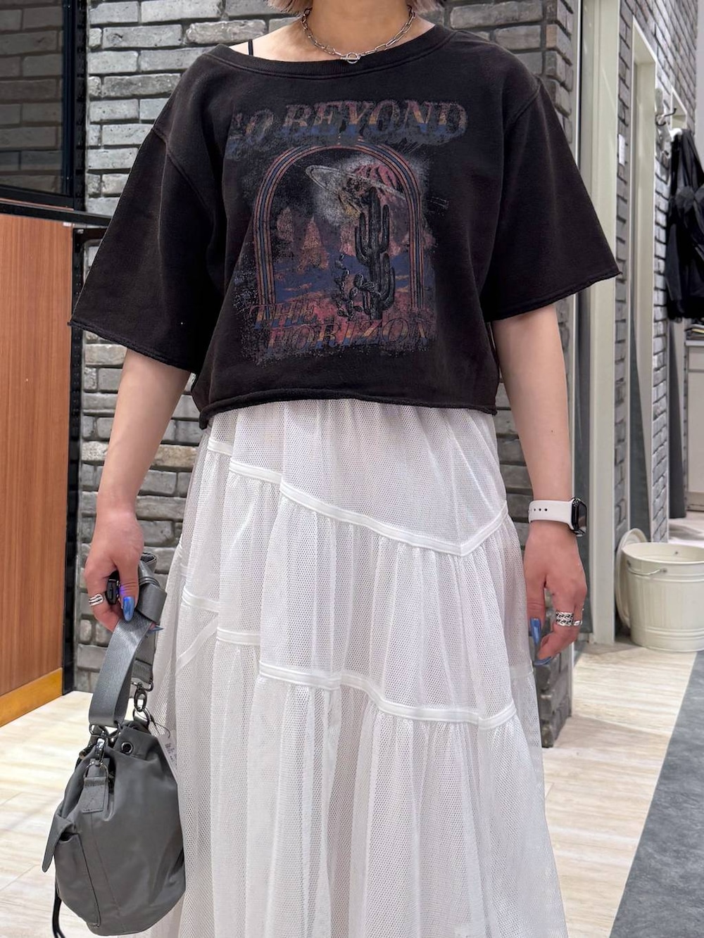 ブラック系のサンダル、ベージュ系のショルダーバッグ、グレー系のTシャツ/カットソーを着用したレディースの春コーディネートの4枚目の写真