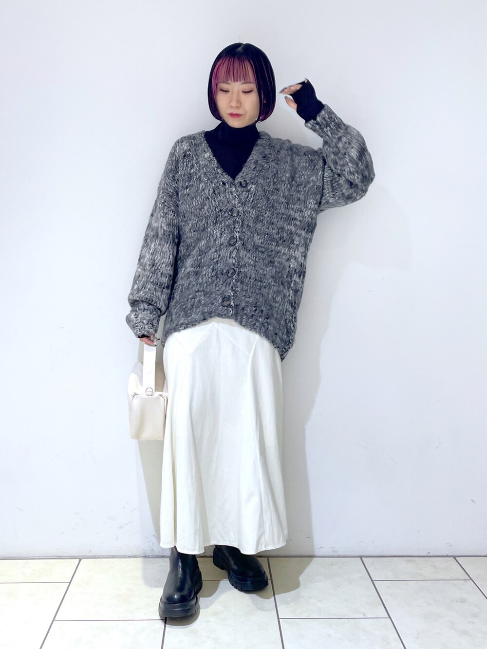 ブラック系のカーディガン/ボレロ、ブラック系のニット/セーター、ホワイト系のショルダーバッグを着用したレディースの秋コーディネートの2枚目の写真