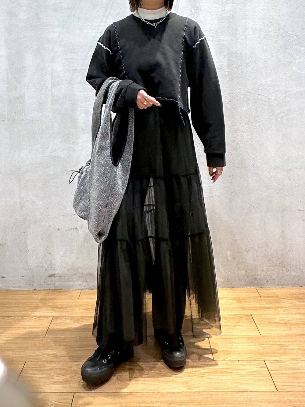 ホワイト系のTシャツ/カットソー、ブラック系のトートバッグ、ブラック系のスカートを着用したレディースの冬コーディネートの5枚目の写真