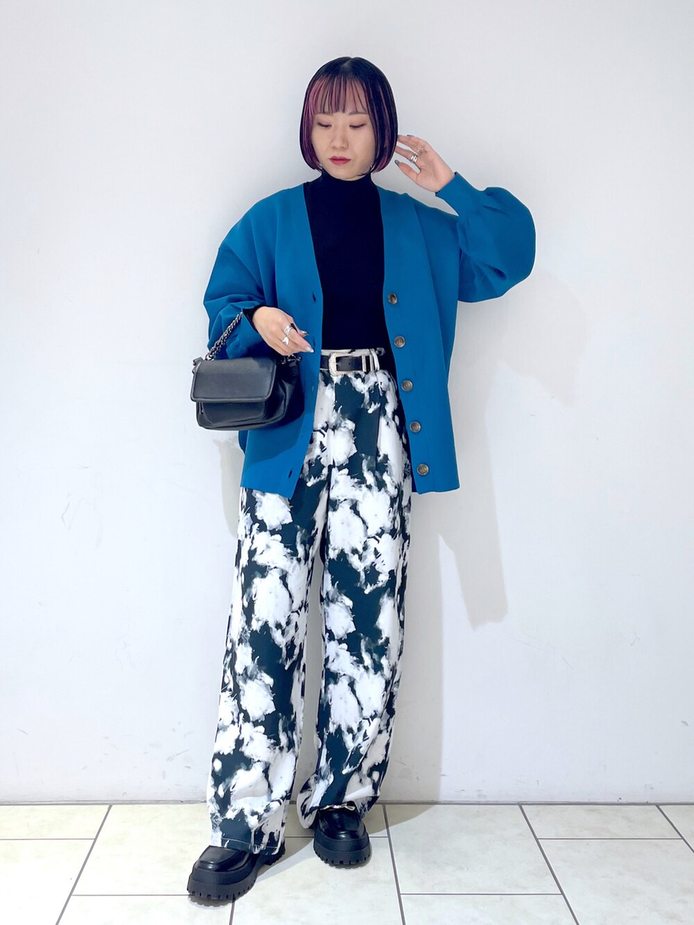 ブラック系のニット/セーター、ブルー系のカーディガン/ボレロ、ブラック系のショルダーバッグを着用したレディースの秋コーディネートの2枚目の写真