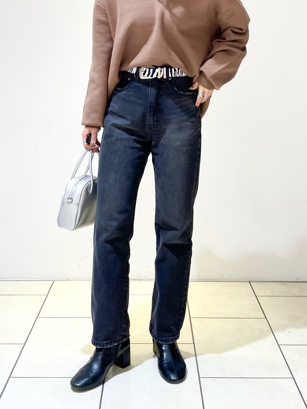 ブラウン系のニット/セーター、ブラック系のニット/セーター、ブラック系のデニムパンツを着用したレディースの春コーディネートの4枚目の写真