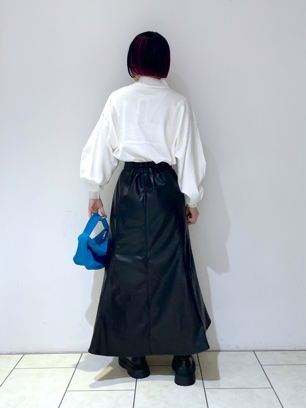 ホワイト系のニット/セーター、ブルー系のハンドバッグ、ブラック系のローファーを着用したレディースの秋コーディネートの3枚目の写真