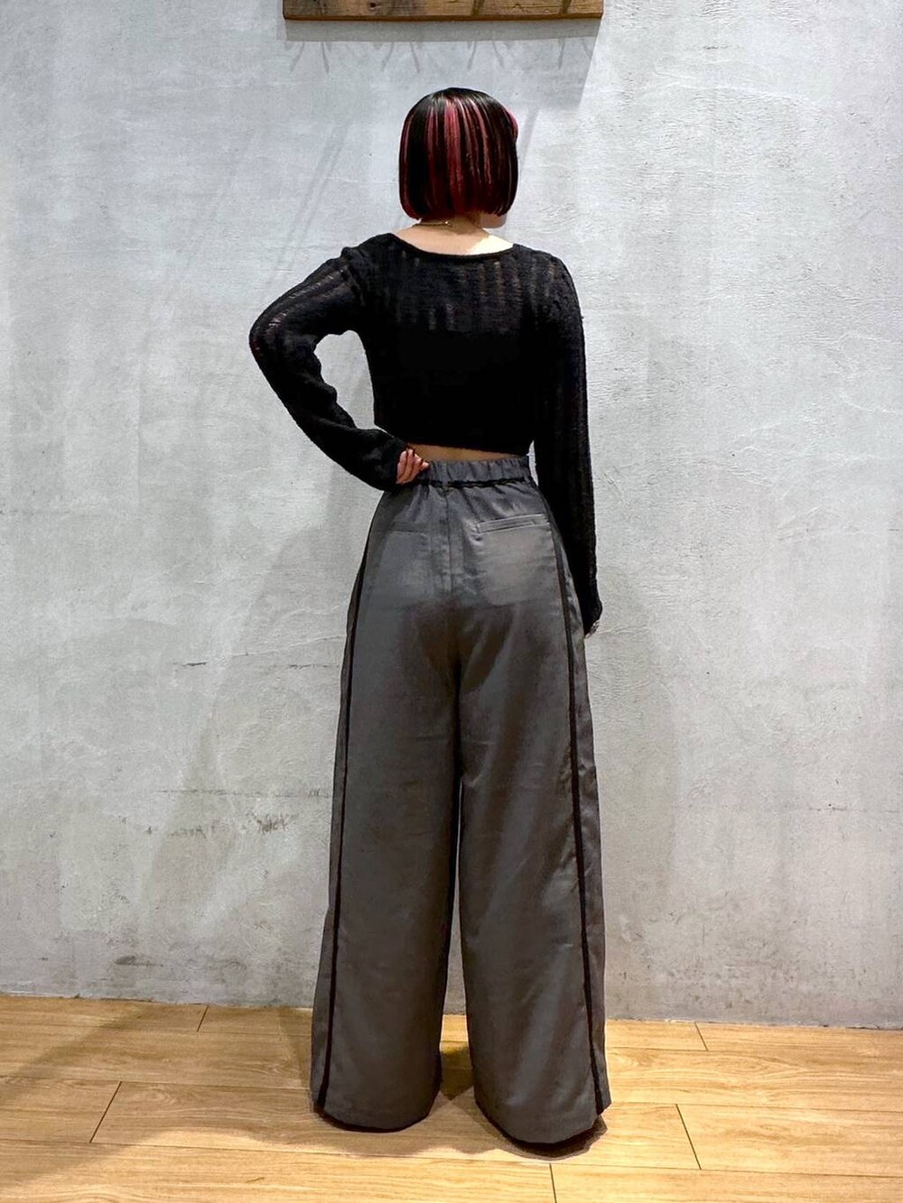 グレー系のスラックス、ブラック系のカーディガン/ボレロ、シルバー系のネックレスを着用したレディースの秋コーディネートの4枚目の写真