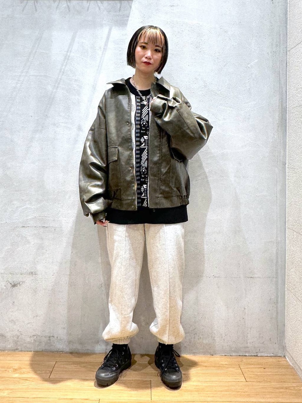 ブラウン系のブルゾン、グレー系のスウェットパンツ、ブラック系のニット/セーターを着用したレディースの秋コーディネートの2枚目の写真