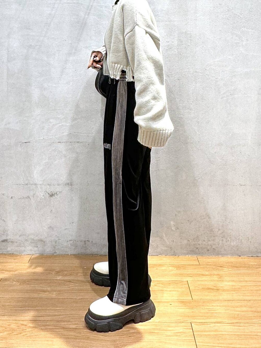 ホワイト系のブーツ、ブラック系のショルダーバッグ、ブラック系のその他パンツを着用したレディースの秋コーディネートの5枚目の写真