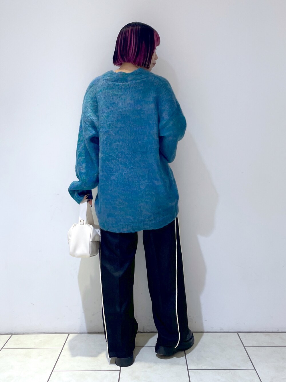 ブルー系のカーディガン/ボレロ、ホワイト系のキャミソール、ブラック系のスラックスを着用したレディースの秋コーディネートの4枚目の写真