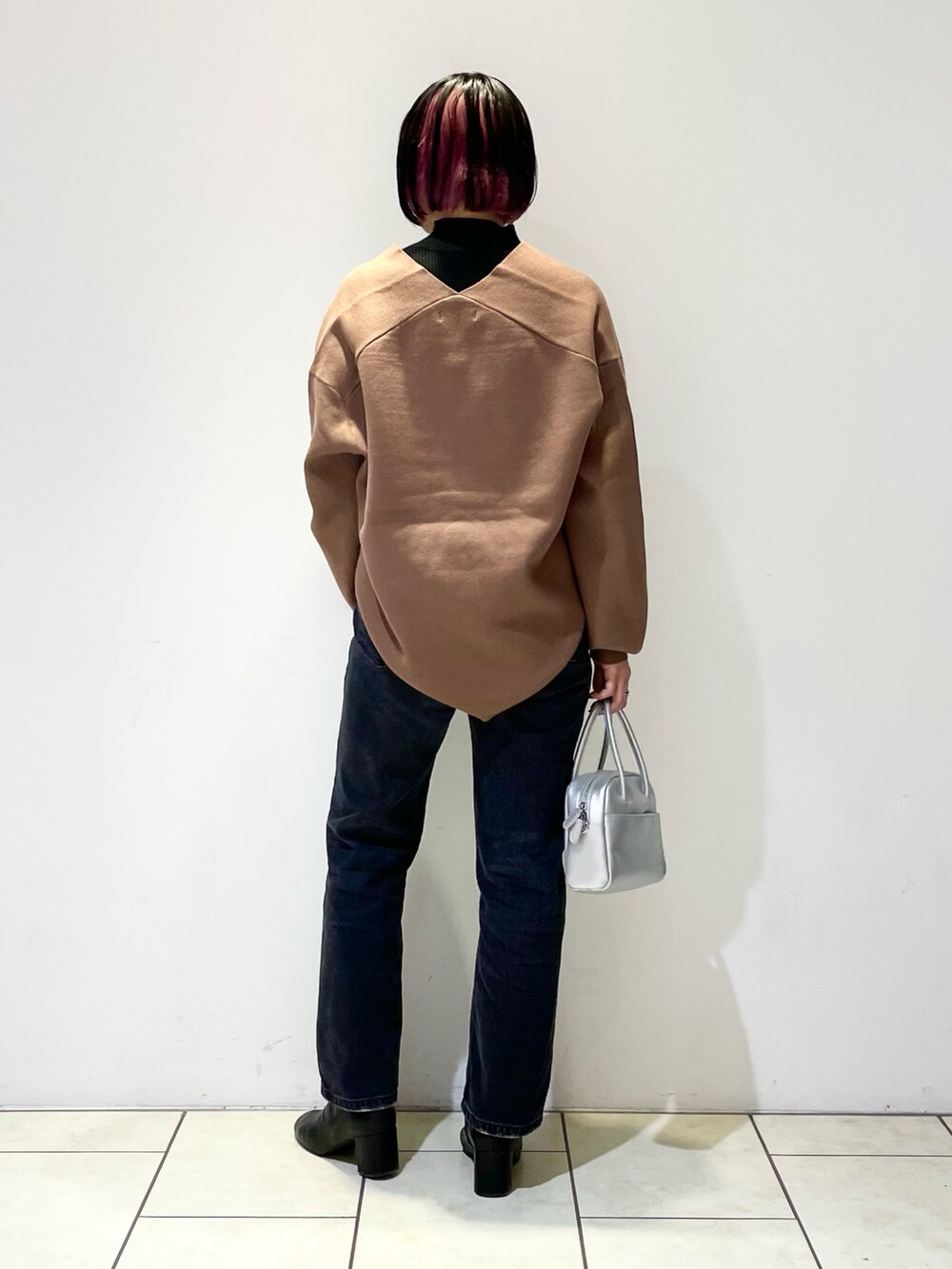 ブラウン系のニット/セーター、ブラック系のニット/セーター、ブラック系のデニムパンツを着用したレディースの春コーディネートの3枚目の写真