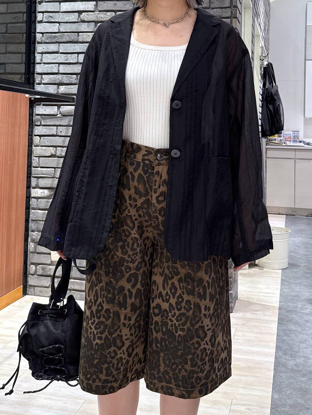 ブラック系のサンダル、ホワイト系のタンクトップ、ブラック系のボディバッグ/ウエストポーチを着用したレディースの春コーディネートの4枚目の写真