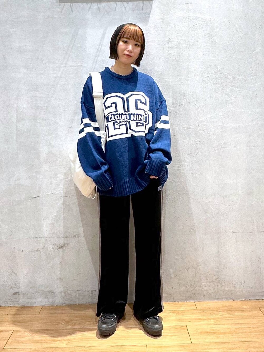 ホワイト系のショルダーバッグ、ブラック系のその他パンツ、ブルー系のニット/セーターを着用したレディースの秋コーディネートの2枚目の写真