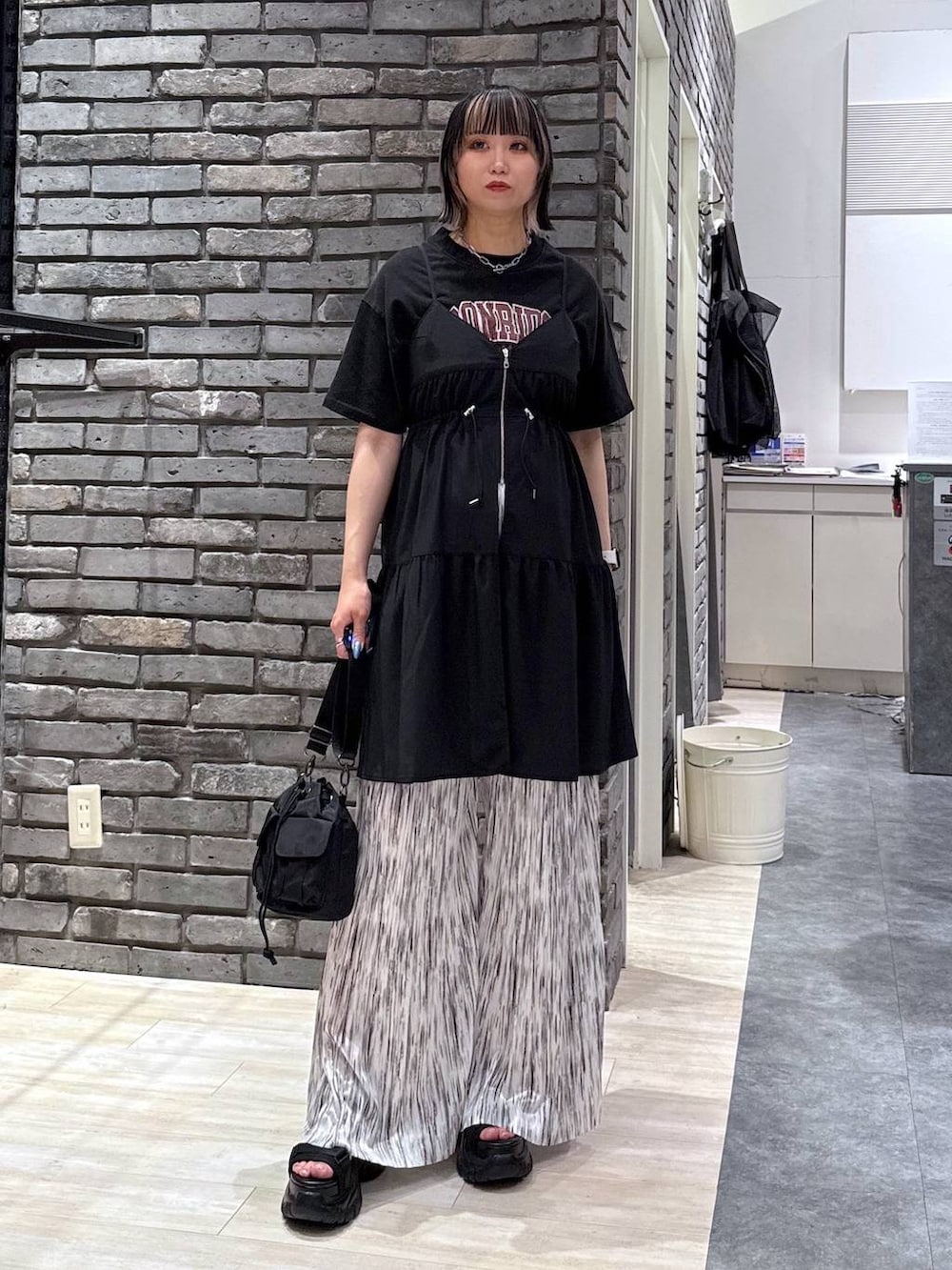 ブラック系のサンダル、ブラック系のショルダーバッグ、ホワイト系のその他パンツを着用したレディースの春コーディネートの2枚目の写真