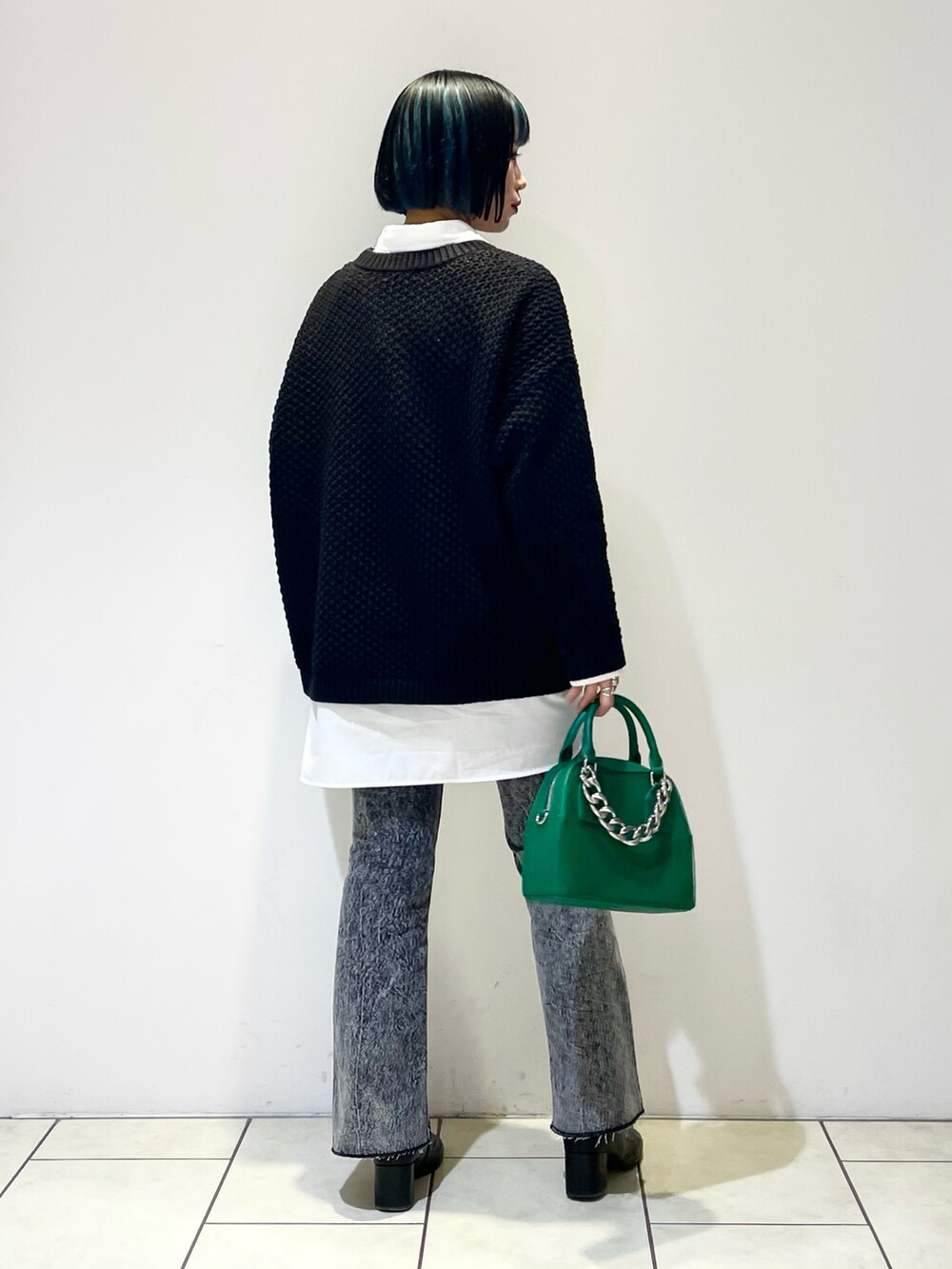 ホワイト系のシャツ/ブラウス、ブラック系のニット/セーター、グリーン系のショルダーバッグを着用したレディースの春コーディネートの4枚目の写真