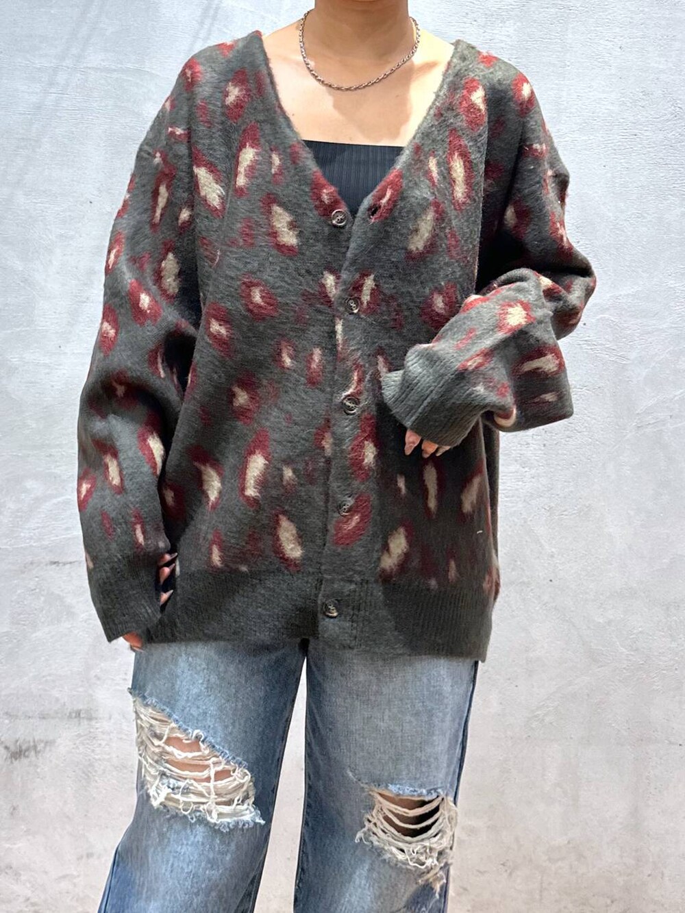 レッド系のカーディガン/ボレロ、ブルー系のデニムパンツ、シルバー系のネックレスを着用したレディースの秋コーディネートの6枚目の写真