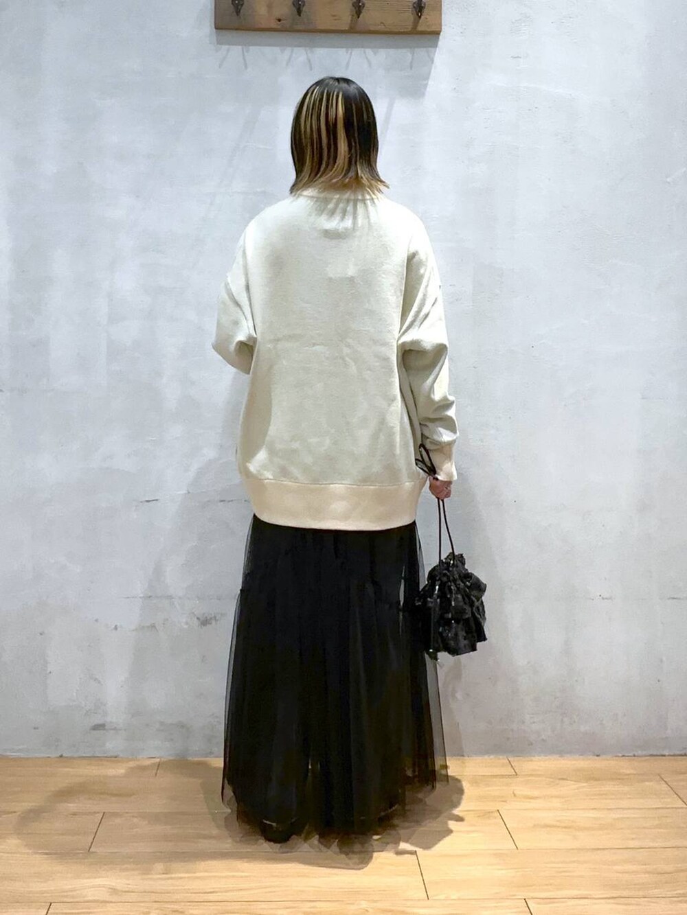 ベージュ系のニット/セーター、ブラック系のデニムパンツ、ブラック系のワンピースを着用したレディースの冬コーディネートの3枚目の写真