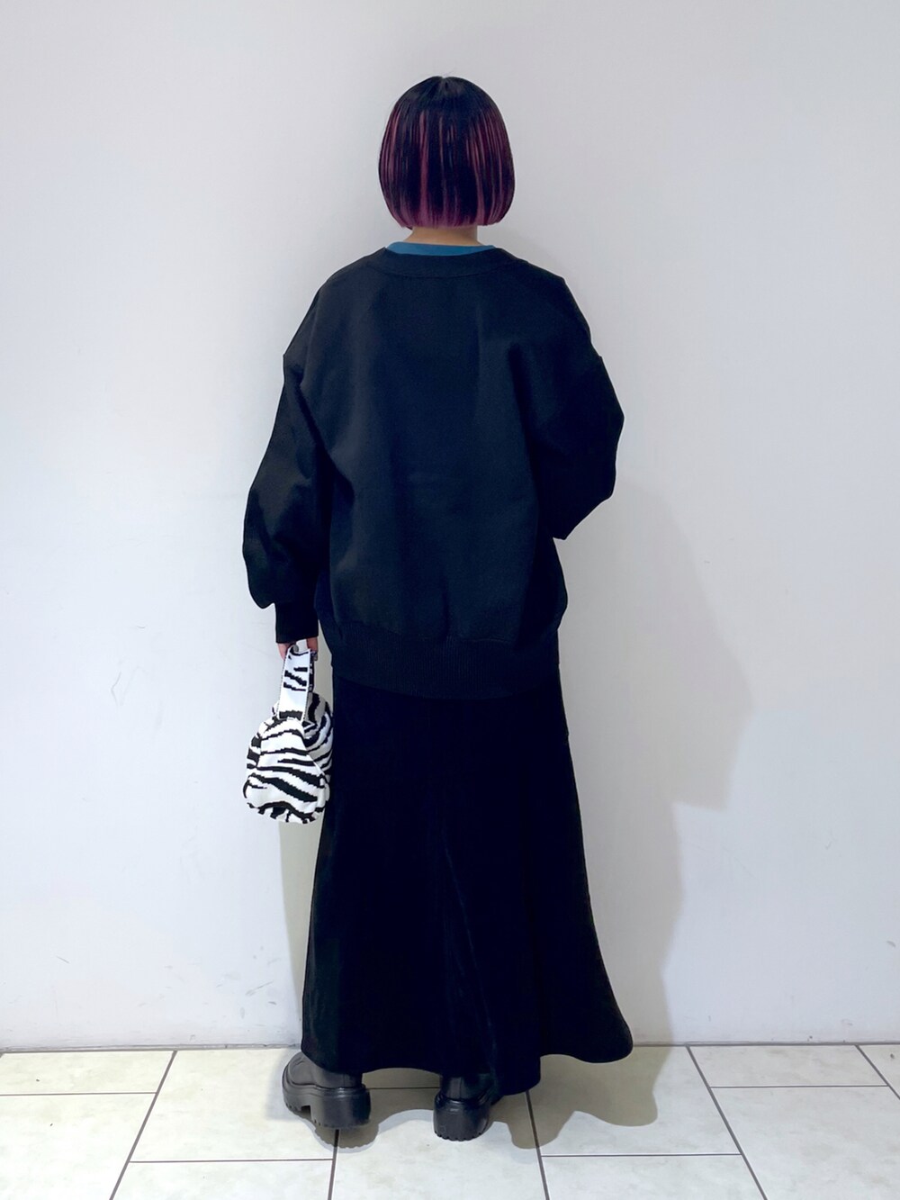 ブラック系のカーディガン/ボレロ、ブルー系のTシャツ/カットソー、ブラック系のスカートを着用したレディースの秋コーディネートの4枚目の写真