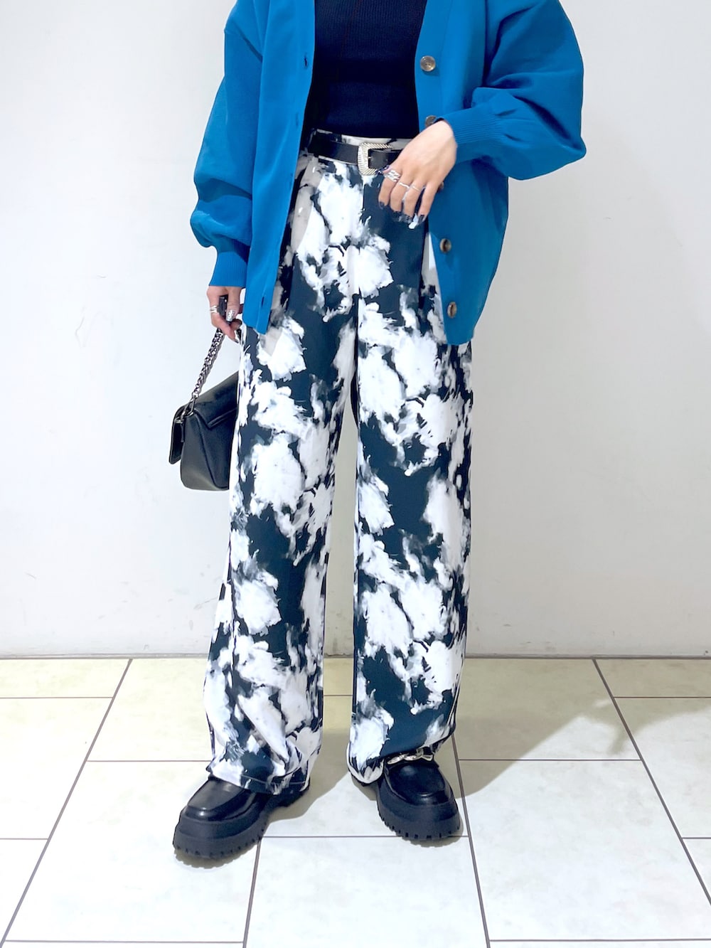 ブラック系のニット/セーター、ブルー系のカーディガン/ボレロ、ブラック系のショルダーバッグを着用したレディースの秋コーディネートの4枚目の写真