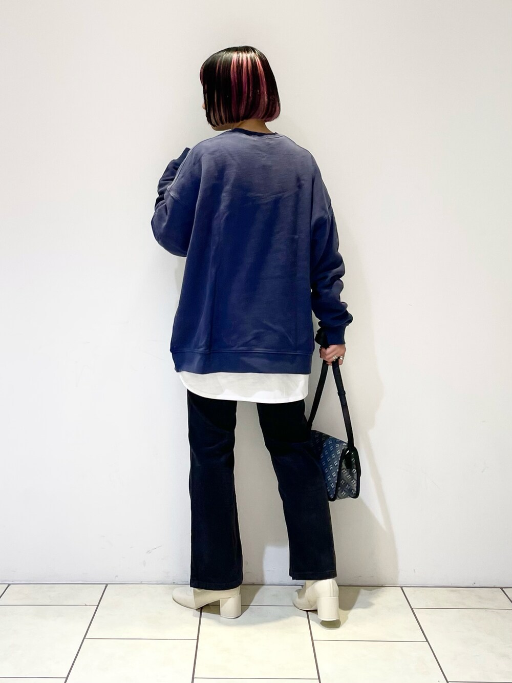 ブルー系のトップス、ホワイト系のTシャツ/カットソー、ブラック系のショルダーバッグを着用したレディースの冬コーディネートの3枚目の写真