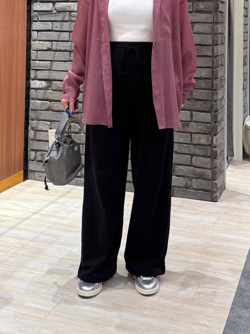 ベージュ系のショルダーバッグ、レッド系のシャツ/ブラウス、ブラック系のスウェットパンツを着用したレディースの春コーディネートの4枚目の写真