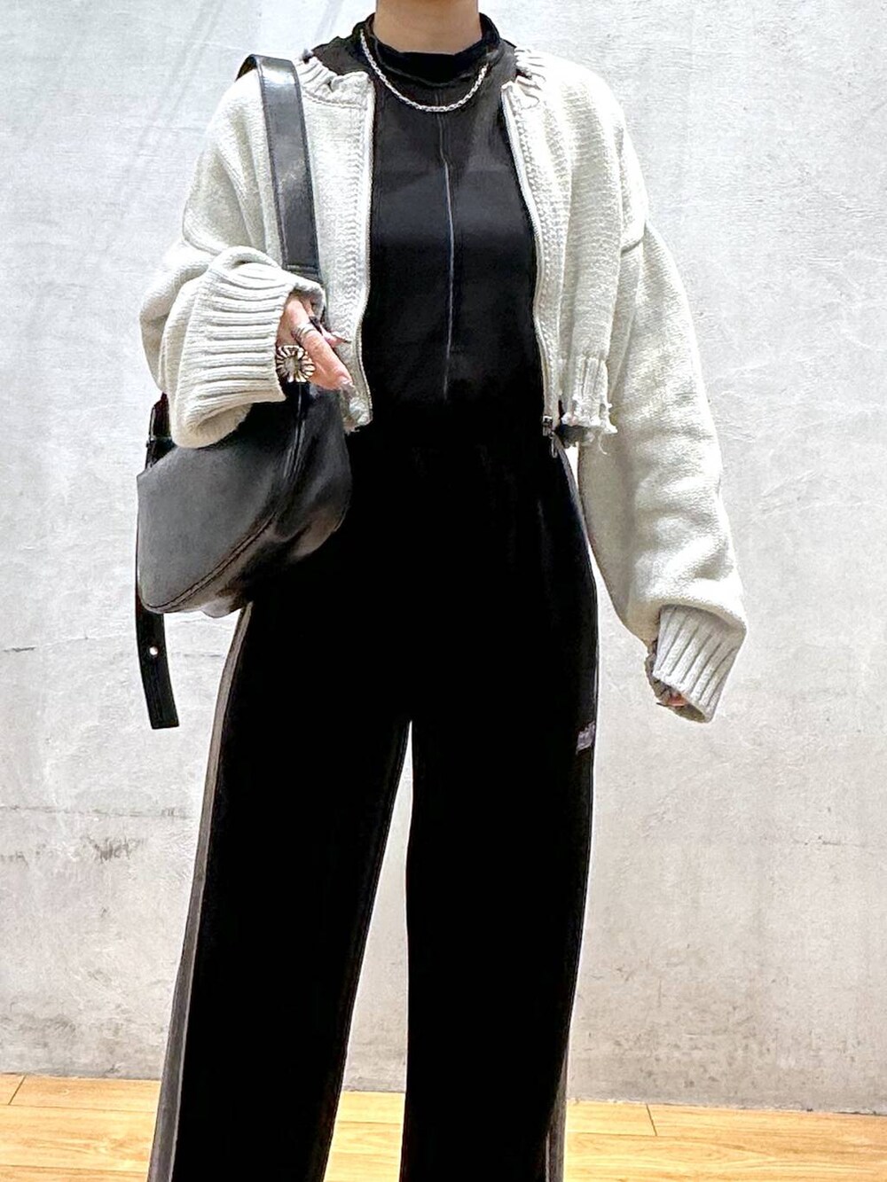 ホワイト系のブーツ、ブラック系のショルダーバッグ、ブラック系のその他パンツを着用したレディースの秋コーディネートの4枚目の写真