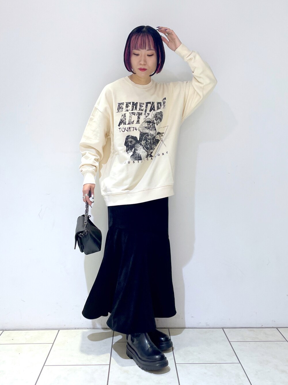 ベージュ系のスウェット、ブラック系のスカート、ブラック系のショルダーバッグを着用したレディースの秋コーディネートの3枚目の写真