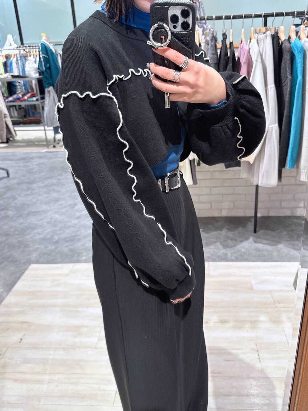 ブラック系のスラックス、ブラック系のカーディガン/ボレロ、ブラック系のベルトを着用したレディースの冬コーディネートの3枚目の写真