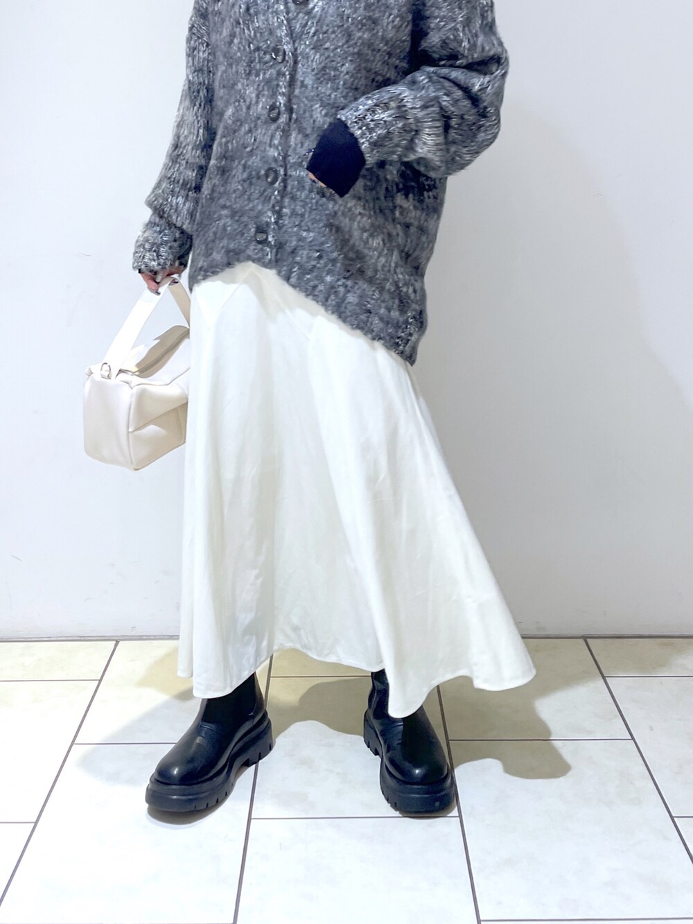 ブラック系のカーディガン/ボレロ、ブラック系のニット/セーター、ホワイト系のショルダーバッグを着用したレディースの秋コーディネートの5枚目の写真