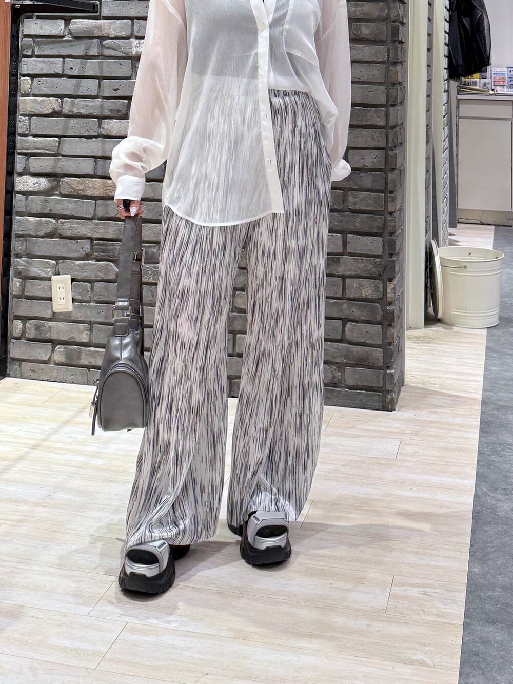 グレー系のサンダル、グレー系のショルダーバッグ、ブラック系のタンクトップを着用したレディースの春コーディネートの6枚目の写真