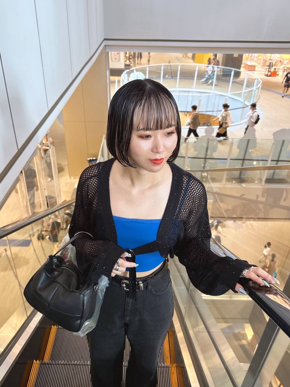 ブルー系のキャミソール、ブラック系のカーディガン/ボレロを着用したレディースの秋コーディネートの2枚目の写真