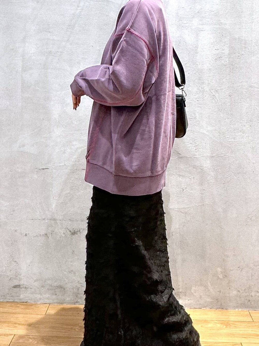 パープル系のスウェット、ブラック系のショルダーバッグ、ブラック系のワンピースを着用したレディースの秋コーディネートの6枚目の写真