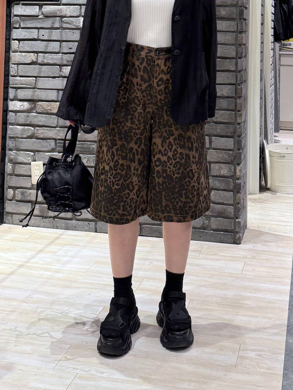 ブラック系のサンダル、ホワイト系のタンクトップ、ブラック系のボディバッグ/ウエストポーチを着用したレディースの春コーディネートの5枚目の写真