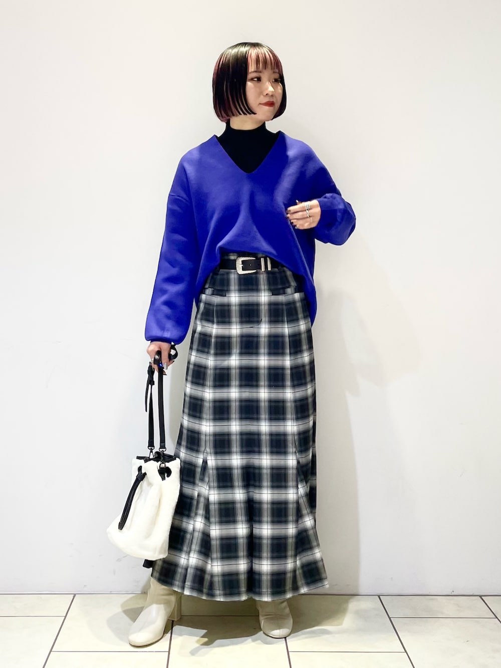 ブラック系のニット/セーター、ブルー系のニット/セーター、ブラック系のスカートを着用したレディースの冬コーディネートの2枚目の写真