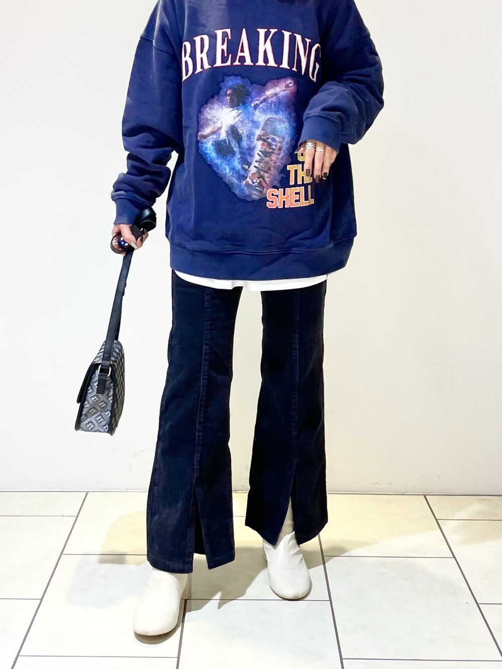 ブルー系のトップス、ホワイト系のTシャツ/カットソー、ブラック系のショルダーバッグを着用したレディースの冬コーディネートの4枚目の写真