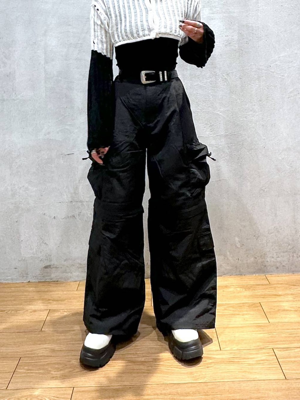 ホワイト系のニット/セーター、ブラック系のカーゴパンツ、ホワイト系のブーツを着用したレディースの冬コーディネートの5枚目の写真