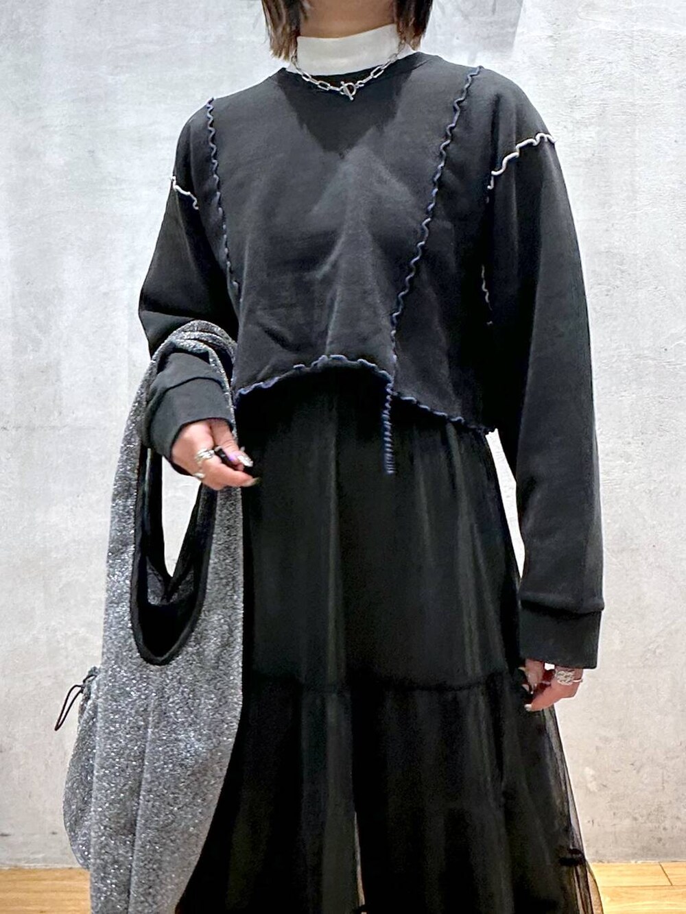 ホワイト系のTシャツ/カットソー、ブラック系のトートバッグ、ブラック系のスカートを着用したレディースの冬コーディネートの7枚目の写真