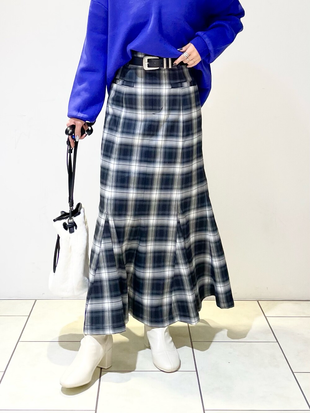 ブラック系のニット/セーター、ブルー系のニット/セーター、ブラック系のスカートを着用したレディースの冬コーディネートの4枚目の写真