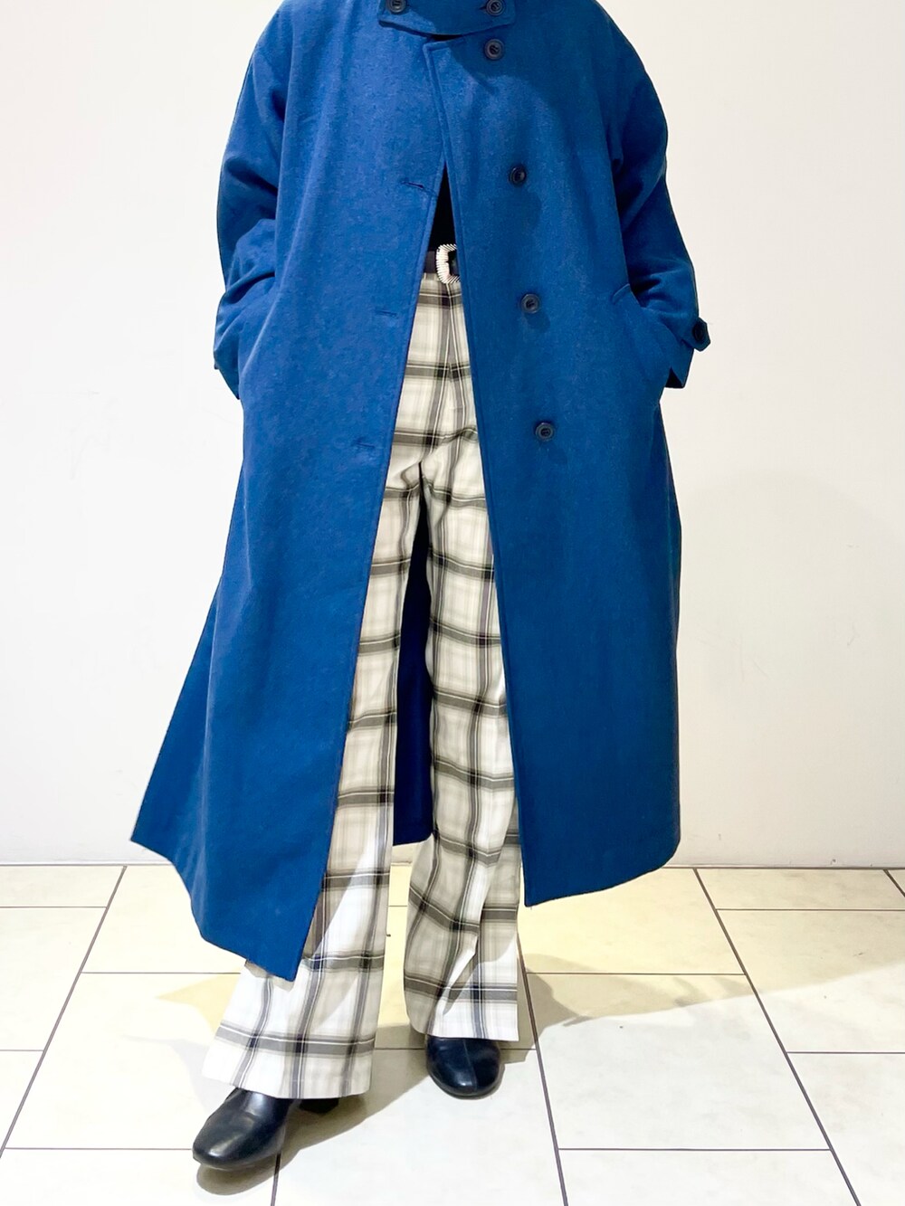 グリーン系のチェスターコート、ブラック系のニット/セーター、ホワイト系のその他パンツを着用したレディースの冬コーディネートの5枚目の写真