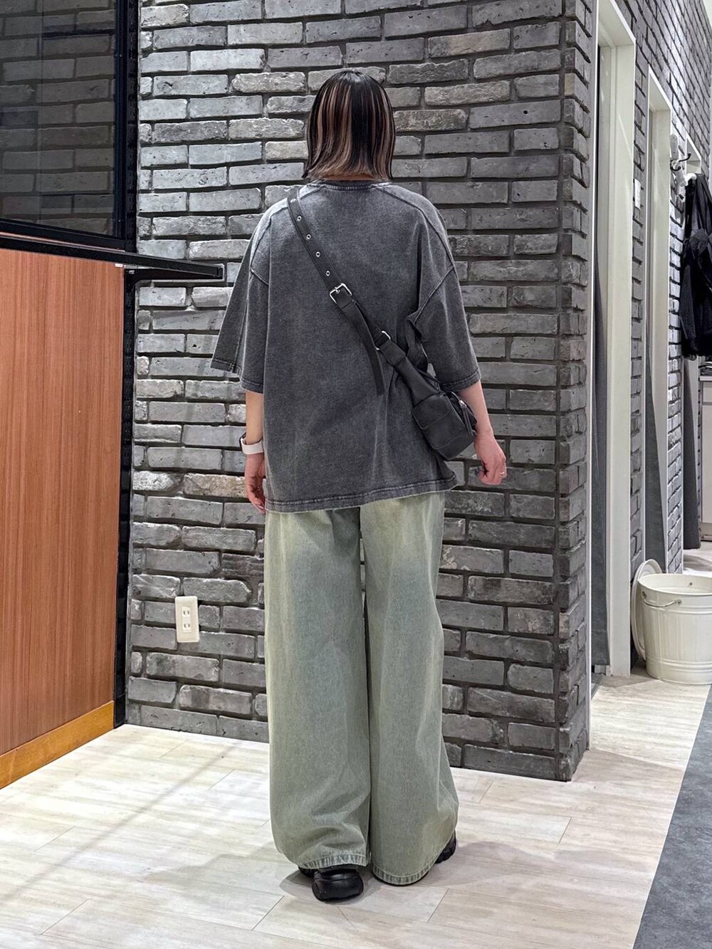 ブルー系のデニムパンツ、ブラック系のサンダル、ブラック系のTシャツ/カットソーを着用したレディースの春コーディネートの4枚目の写真