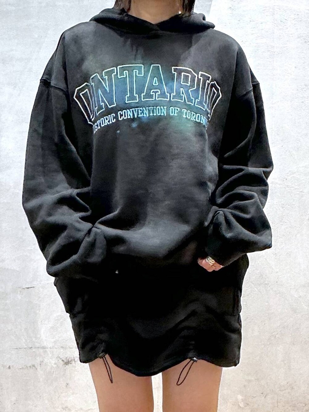 ブラック系のブーツ、ブラック系のパーカー、ブラック系のスカートを着用したレディースの冬コーディネートの3枚目の写真