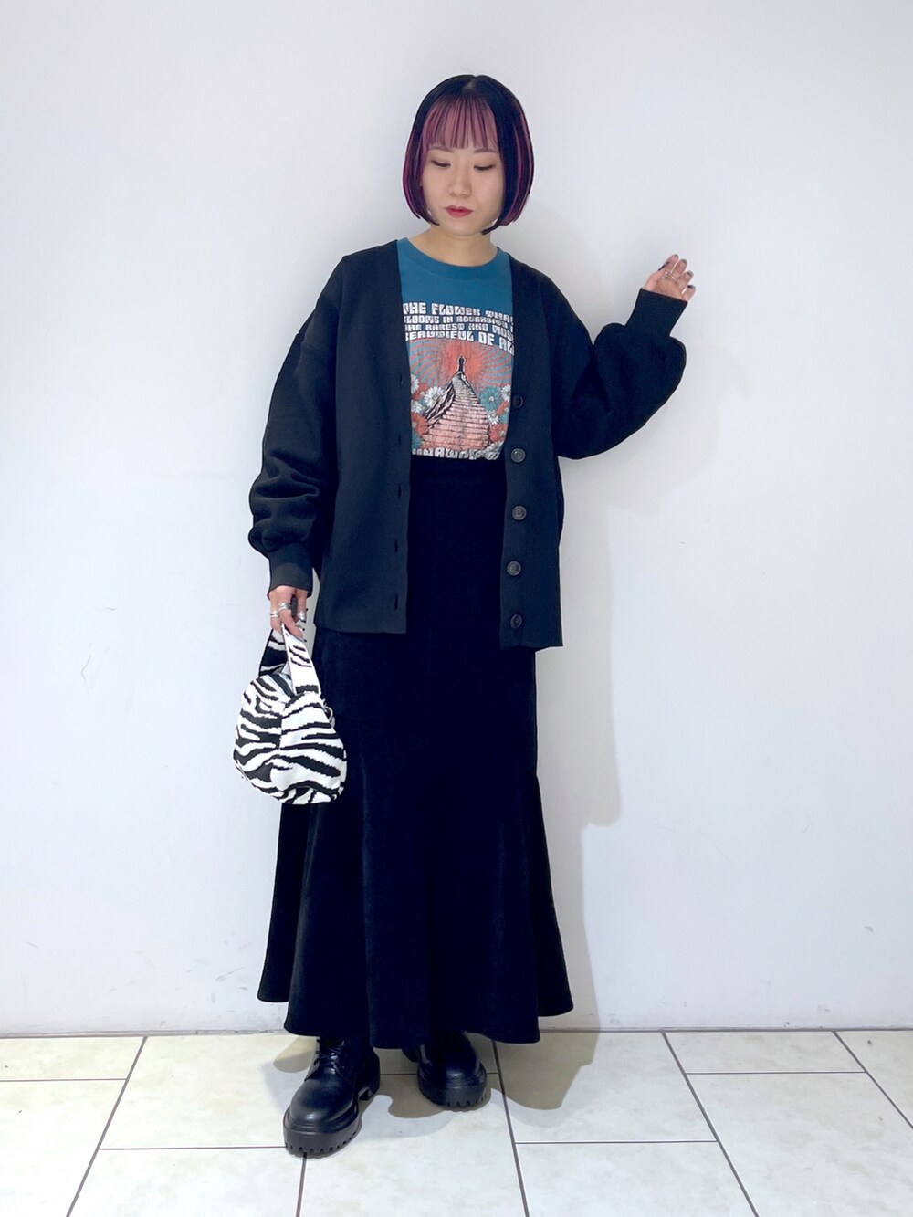 ブラック系のカーディガン/ボレロ、ブルー系のTシャツ/カットソー、ブラック系のスカートを着用したレディースの秋コーディネートの2枚目の写真