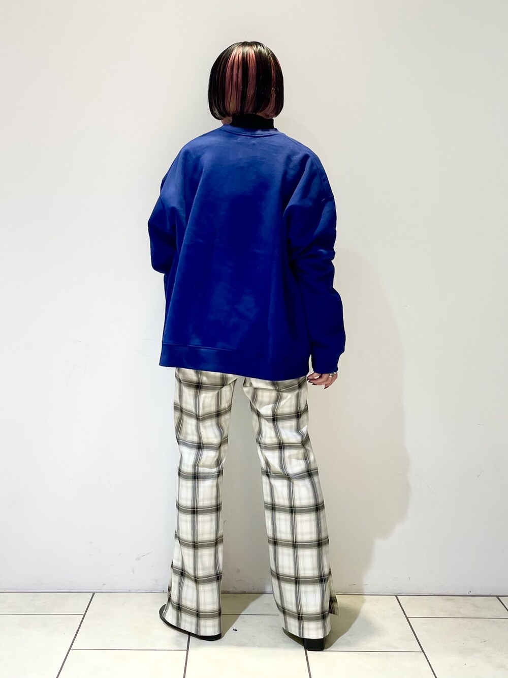 ブラック系のニット/セーター、ホワイト系のその他パンツ、ブラック系のブーツを着用したレディースの冬コーディネートの4枚目の写真