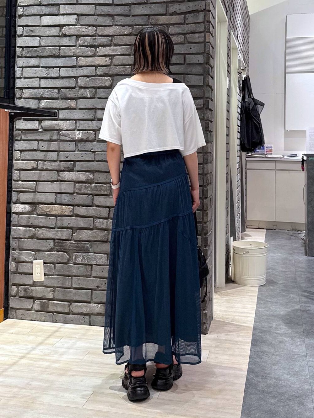 ブラック系のサンダル、ブラック系のショルダーバッグ、ブルー系のスカートを着用したレディースの春コーディネートの3枚目の写真