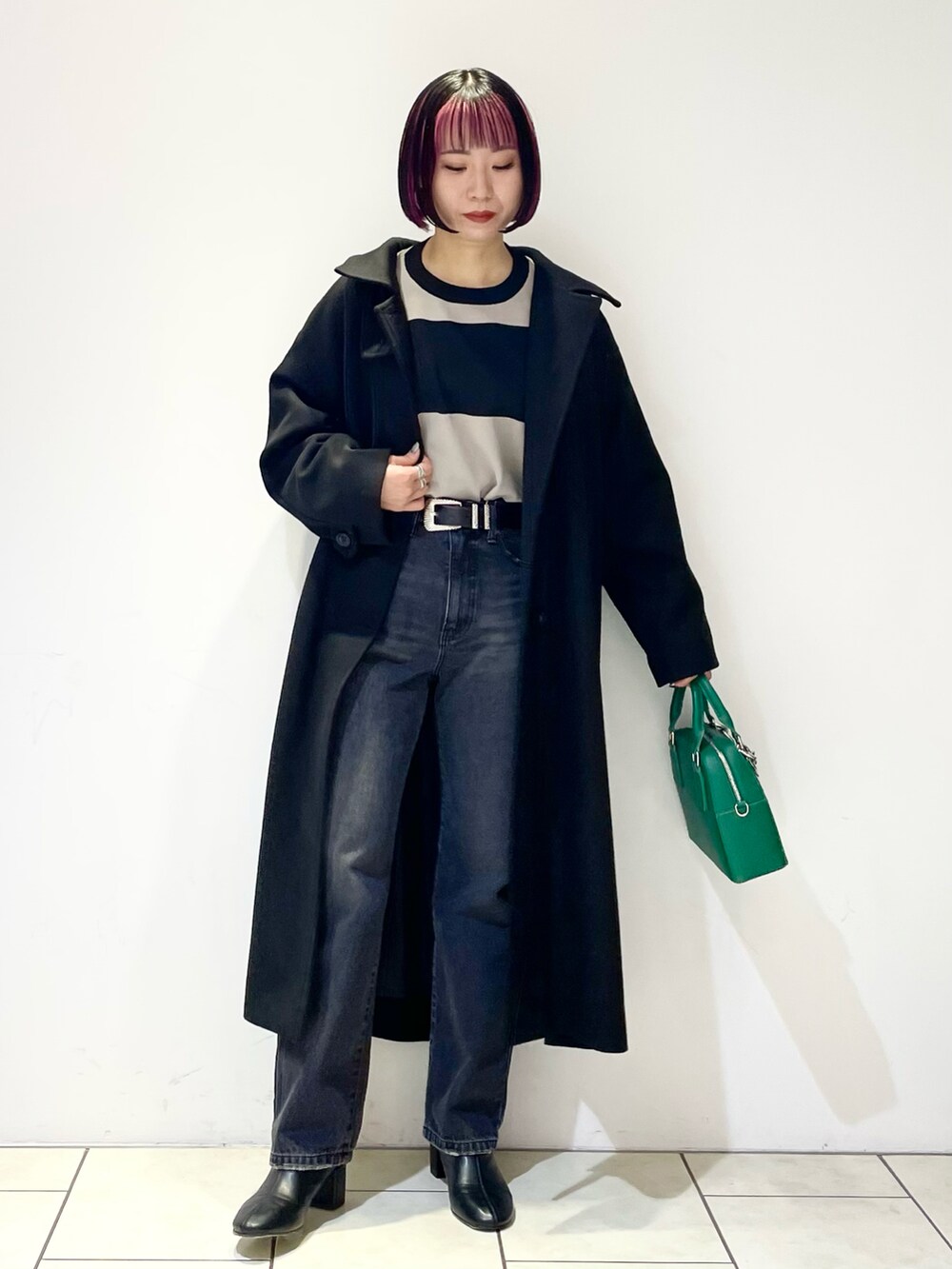 ブラック系のニット/セーター、ブラック系のチェスターコート、ブラック系のデニムパンツを着用したレディースの冬コーディネートの2枚目の写真